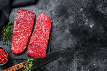 Raw Denver steak. Marble beef meat. Black background. Top view. Copy space