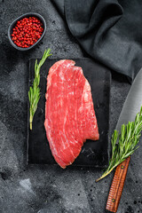 Flank steak. Raw Marble beef meat black Angus. Black background. Top view