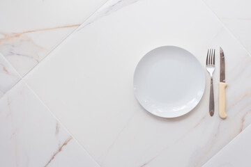 Empty ceramics plate isolated on white marble background. Copy space. Menu Recipe Concept
