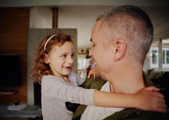 Young father holding girl child in hand while looking at each other