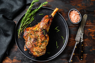 BBq Roasted goat leg. Farm meat. Dark Wooden background. Top view