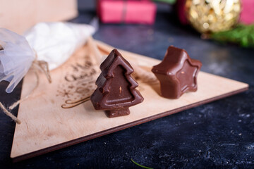 A wooden box gift with a marshmallows for coffee and spoons with chocolates in the form of a star Christmas tree. New Year's content.