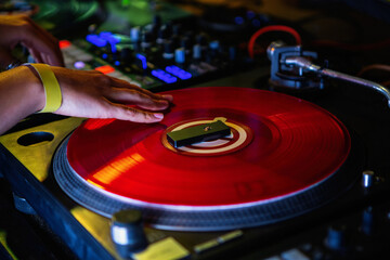 Dj girl scratches vinyl record with music on hip hop party in nightclub.Professional female disc...