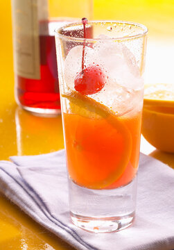 A classic Longdrink cocktail made with Campari, freshly squeezed orange juice, ice, orange slices, and cocktail cherries