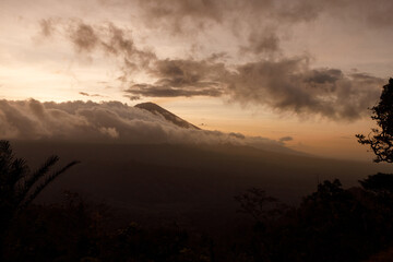Silhouette of volcano Agung in the fog and clouds during sunset just before the rain