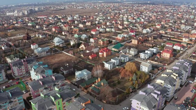 A lot of housing in the suburbs of the city - low-density development outside the city. Drone flight over cottages, duplexes and multi-family homes. Tilt Reveal Drone Shot. 