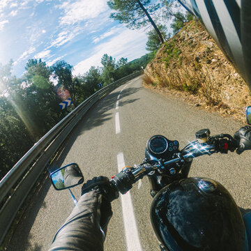 Riding a retro old black motorbike rider point of view on a winding road