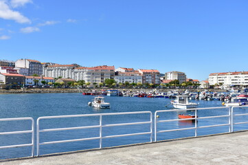 Harbour and coastal village with galician fishing vessels, rowboats and sailing boats at famous...
