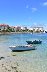 Fototapeta na wymiar Harbor and coastal village with rowboats and galician fishing vessels at famous Rias Baixas in Galicia Region. Portosin, Coruña, Spain. 