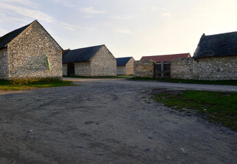 Fototapeta na wymiar Kamienne stodoły z końca XIX i początku XX w Zarkach w promieniach zachodzącego słońca
