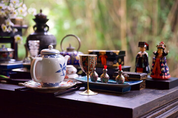 teapot and decorative wine glass in focus on the foreground, tea ceremony in the east, clay teapot and green tea cup, Chinese tradition of tea drinking