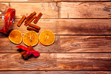 Dried oranges with cinnamon on a wooden table