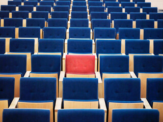 Rows Of Blue Armchairs And One Red