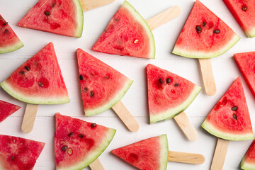 Slices of ripe watermelon on white wooden table, flat lay