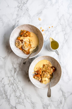 Apricot And Almond Crumble In Serving Bowls With Custard