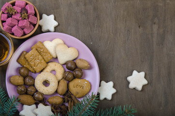 Cookies in a saucer, sugar in a wooden bowl and spruce branches.