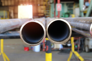 Large diameter pipes are stacked in an industrial factory shop