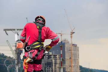 Safety concept the man wearing full safety harness for rope access in construction site with copy...