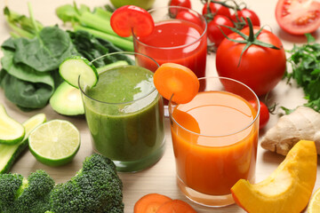 Delicious vegetable juices and fresh ingredients on wooden table