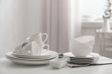 Set of clean dishware on white table indoors