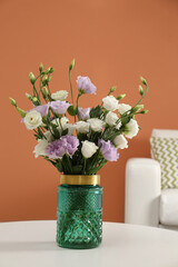 Bouquet of beautiful Eustoma flowers on table in living room