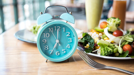 Time to lose weight and selective focus of blue clock and eating control or time to diet...