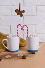 Christmas cookies hanging over marshmallow mugs red and white christmas candy cane