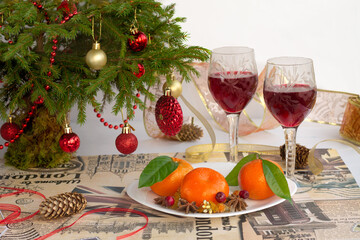 Merry Christmas! Two glasses of wine, Christmas tree, tangerines. New years treat: red wine, tangerines