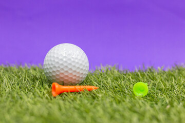 Golf ball and tee are on purple background