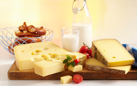 A cheese still life with pretzels and milk
