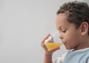 child holding glass of orange fruit juice promoting healthy eating on white background stock photo