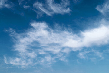 Naklejka na ściany i meble White feathery fluffy clouds on a blue sky, background and texture