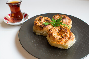 Delicious buns on a black plate on a white background