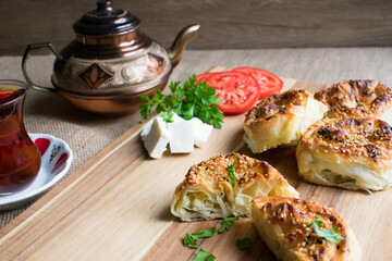 Delicious pies on wooden background with cheese,tomato,parsley, cheese and tea