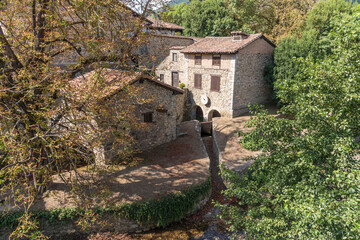 Fototapeta na wymiar Traditional stone-made buildings surrounded by lush vegetation in Potes, Cantabria, Spain