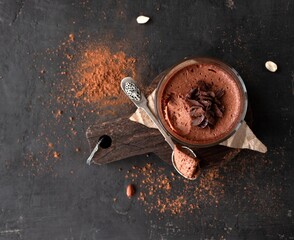 Vegan chocolate mousse glass on a dark background with space for text. Top view. Flat lay