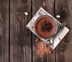 Vegan chocolate mousse glass on a dark wooden background with space for text. Top view. Flat lay