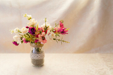 Close-up of a gentle floral composition in a vase on the light background