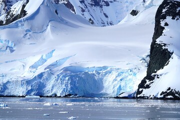 Fototapeta na wymiar Summer landscape in Antarctica with melting snow, sea, icebergs, mountains
