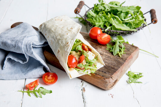 A wrap with tomatoes, mozzarella and rocket salad