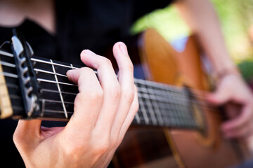 Fototapeta na wymiar Spanish guitar. Man playing Spanish guitar with detail on his hands