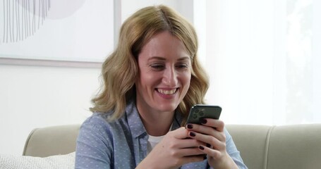 Mykolaiv, Ukraine - November 16, 2020: Beautiful woman using modern phone at home