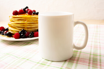 White coffee mug mockup with pancakes and berries