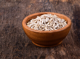 Sunflower seeds in wood bowl on wooden