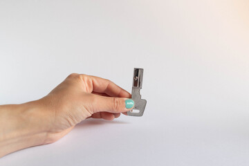 Hand holding a key shaped pencil sharpener on white background