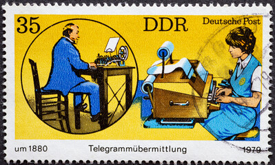 a postage stamp from Germany, GDR showing a telegram transmission in 1880 with a telegraph and in...