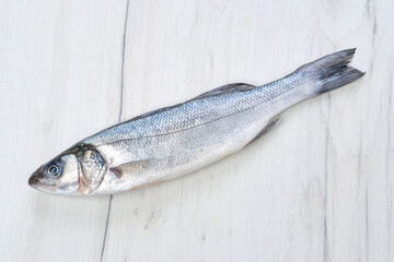 Seabass fish on white wooden table