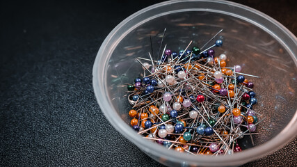 pins collected in a jar with a dark background