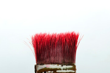 Closeup of red bristle of brush against white background