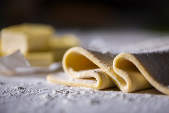 Puff pastry with flout on a wooden surface